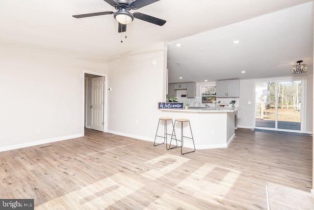 unfurnished living room with light wood-type flooring and ceiling fan