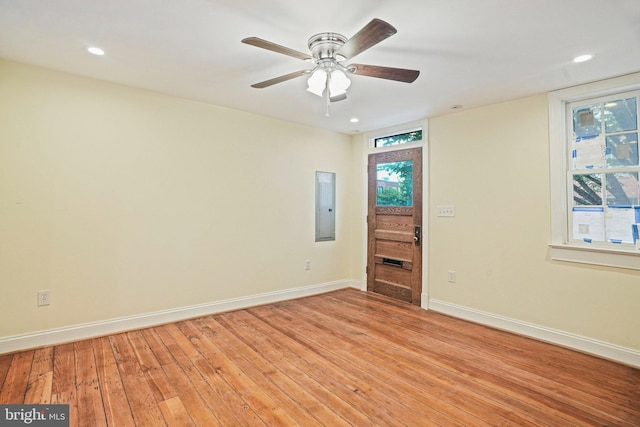 unfurnished room featuring ceiling fan, electric panel, and light hardwood / wood-style flooring