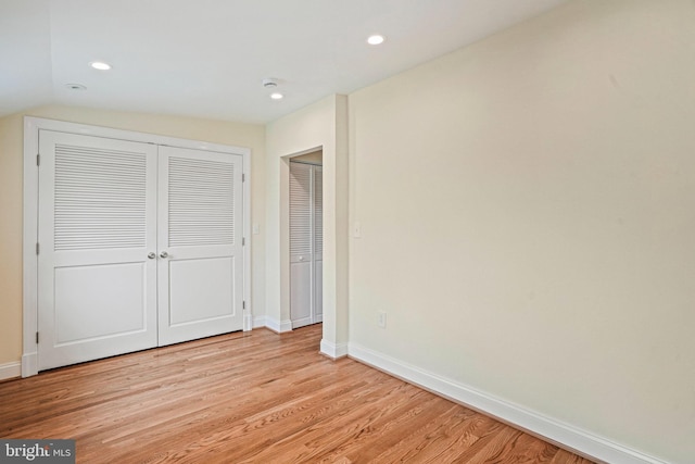 unfurnished bedroom with a closet and light wood-type flooring