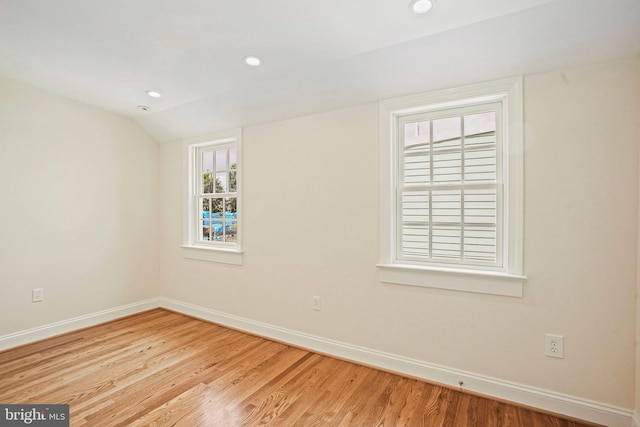 unfurnished room with vaulted ceiling and light hardwood / wood-style floors