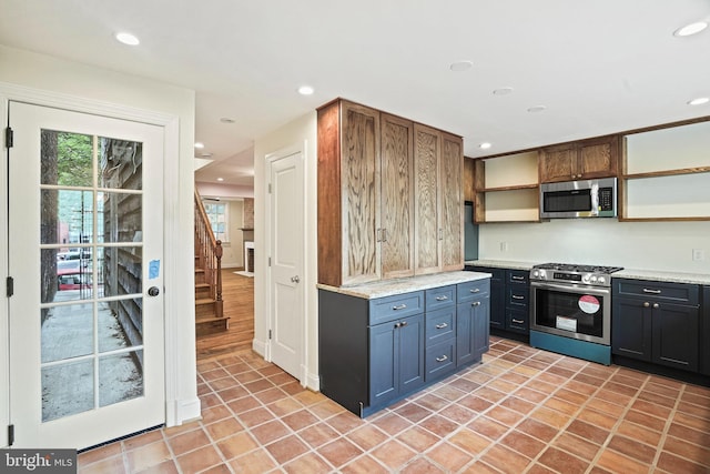 kitchen with light stone counters, light tile patterned floors, and stainless steel appliances