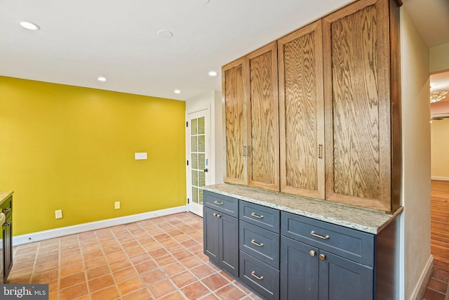 kitchen with light tile patterned flooring and light stone countertops