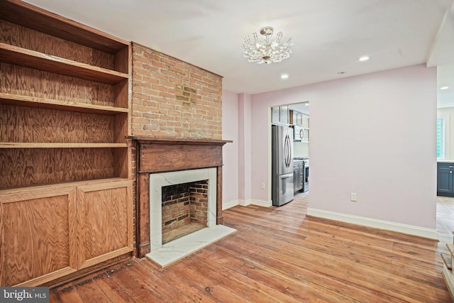 unfurnished living room with a fireplace and light hardwood / wood-style floors