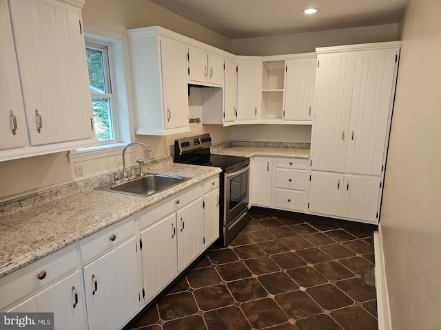 kitchen with white cabinetry, sink, light stone counters, and stainless steel electric range