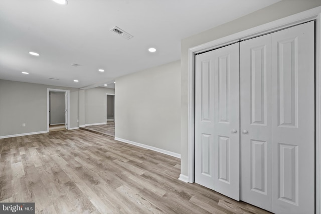 unfurnished bedroom with light wood-type flooring and a closet