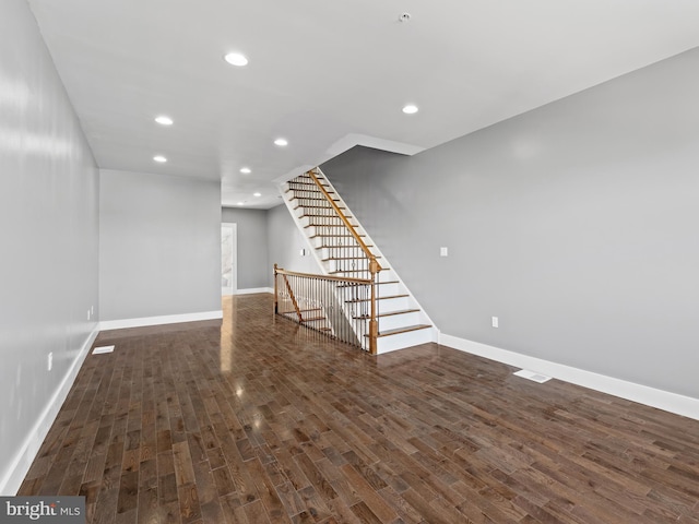 below grade area featuring recessed lighting, baseboards, wood finished floors, and stairs