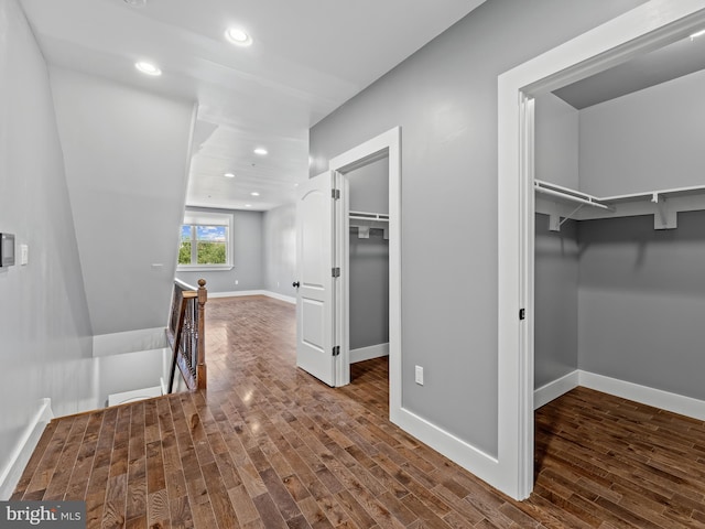 corridor featuring an upstairs landing, recessed lighting, baseboards, and wood finished floors