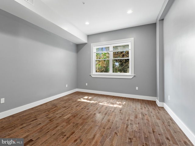 empty room featuring recessed lighting, baseboards, and wood finished floors