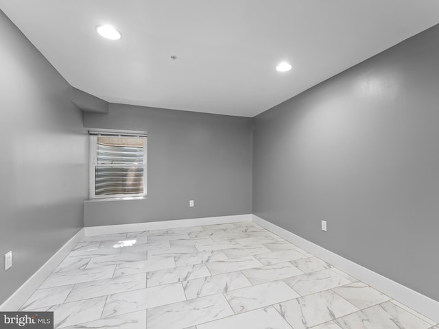 empty room featuring recessed lighting, baseboards, and marble finish floor