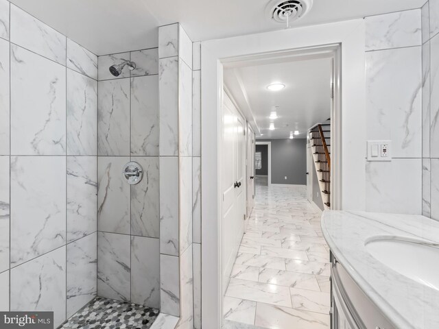 bathroom with vanity and tiled shower