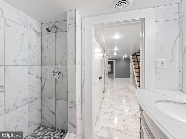 full bathroom featuring vanity, visible vents, marble finish floor, and a tile shower