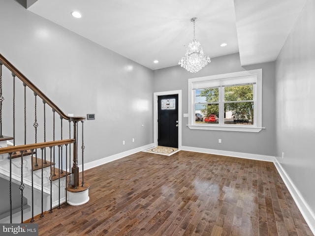 entryway with dark hardwood / wood-style flooring and a notable chandelier