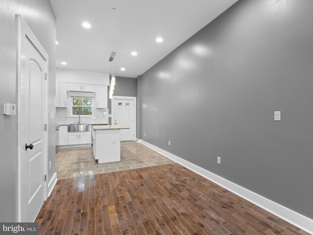 unfurnished living room featuring sink and light hardwood / wood-style floors