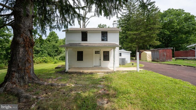 view of front facade featuring a garage, an outdoor structure, and a front yard