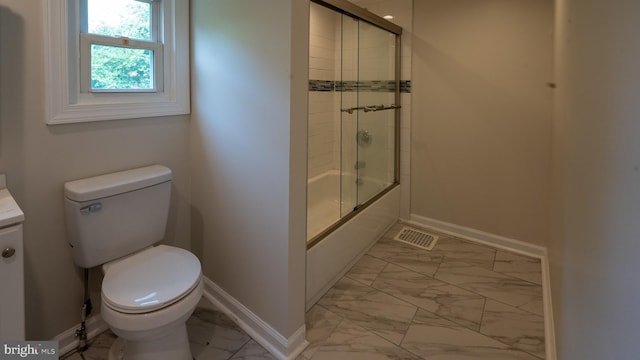 full bathroom featuring bath / shower combo with glass door, vanity, and toilet