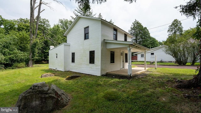 rear view of property featuring a yard and a patio