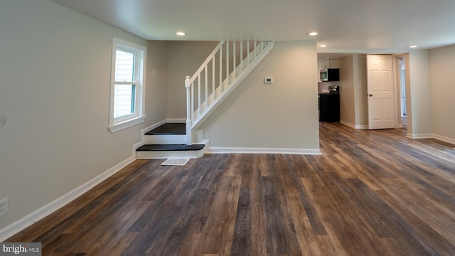 unfurnished living room with dark hardwood / wood-style flooring