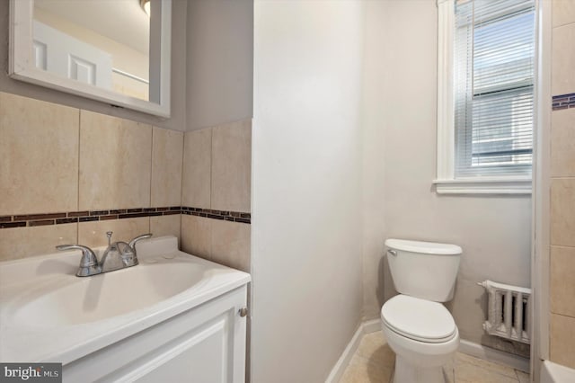 bathroom featuring vanity, toilet, a healthy amount of sunlight, and tile patterned flooring