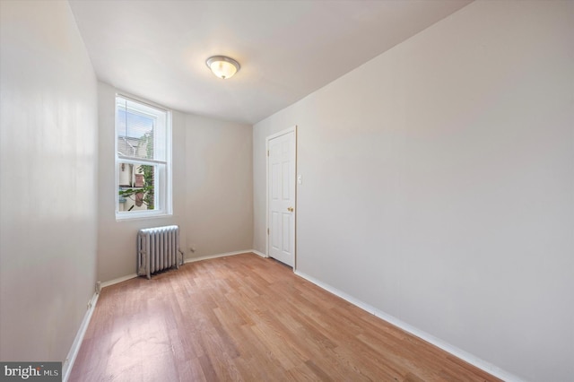 unfurnished room with radiator and light hardwood / wood-style flooring