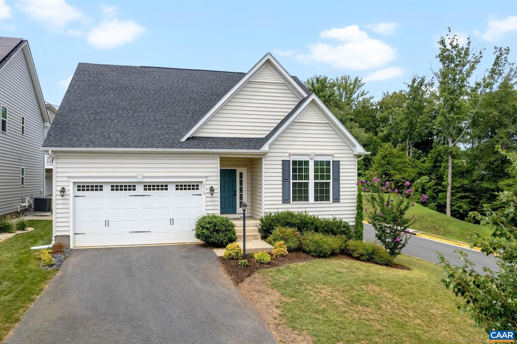 view of front facade with a garage, central AC unit, and a front yard