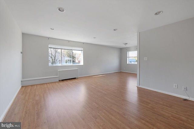 empty room with radiator and light hardwood / wood-style floors