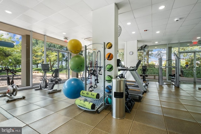 exercise room featuring a paneled ceiling and expansive windows