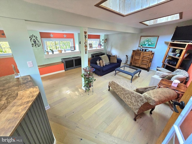 living room featuring a skylight and light wood-type flooring