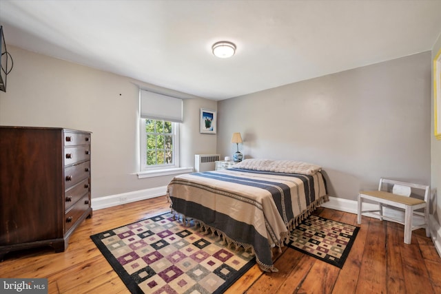 bedroom featuring hardwood / wood-style flooring and radiator