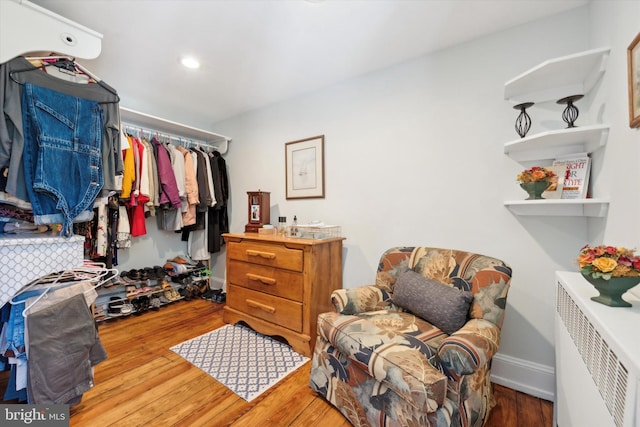 walk in closet featuring hardwood / wood-style floors and radiator