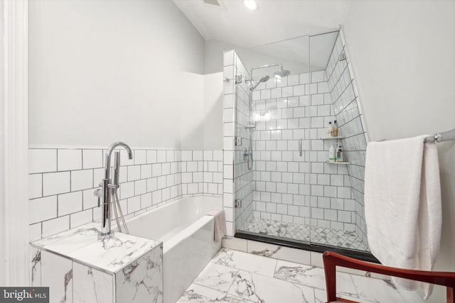 bathroom featuring shower with separate bathtub