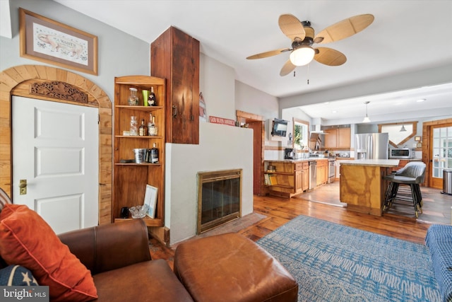 living room with ceiling fan and light wood-type flooring