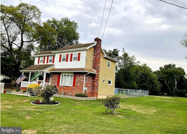 view of front facade featuring covered porch and a front yard