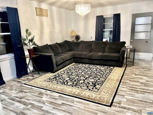 living room featuring wood-type flooring, a chandelier, and a textured ceiling