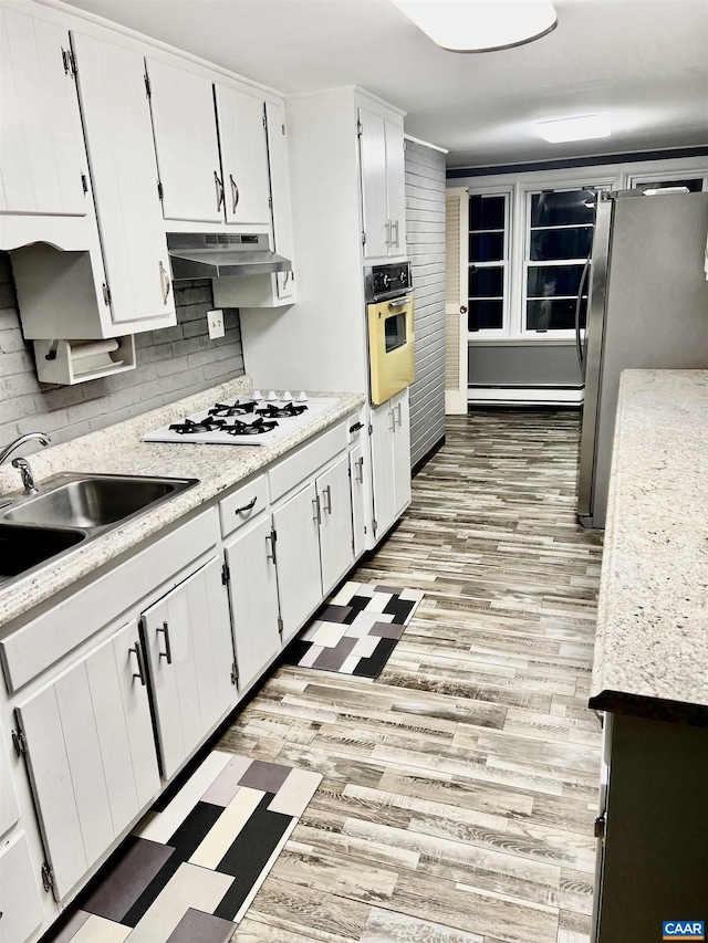 kitchen featuring white cabinets, light wood-type flooring, and stainless steel appliances