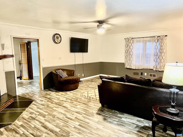 living room featuring ornamental molding, hardwood / wood-style floors, and ceiling fan