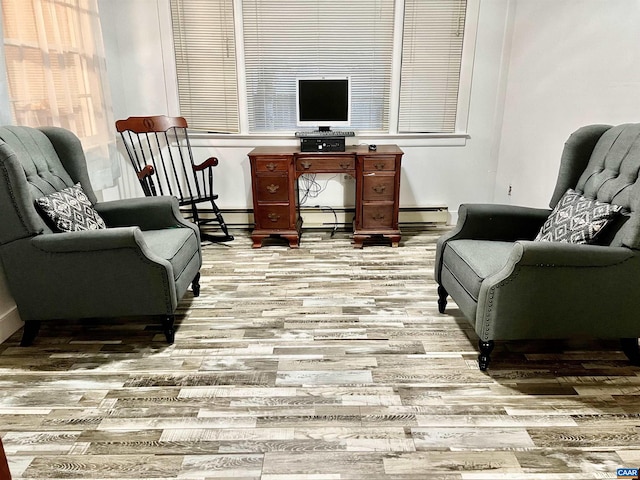 sitting room featuring baseboard heating and hardwood / wood-style floors