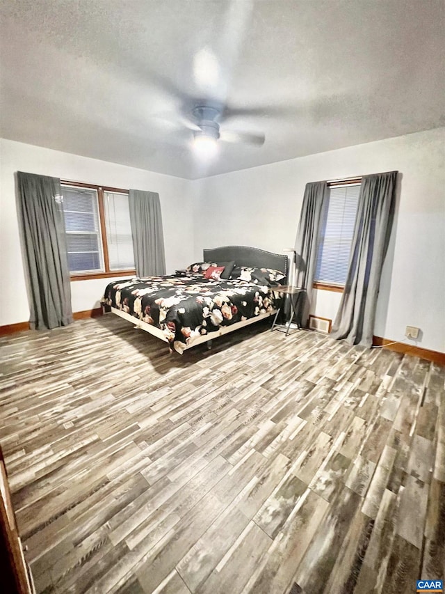 bedroom with wood-type flooring, a textured ceiling, and ceiling fan