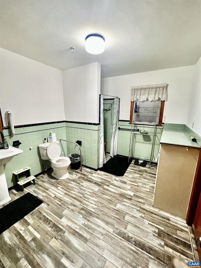 bathroom featuring toilet, hardwood / wood-style floors, and tile walls