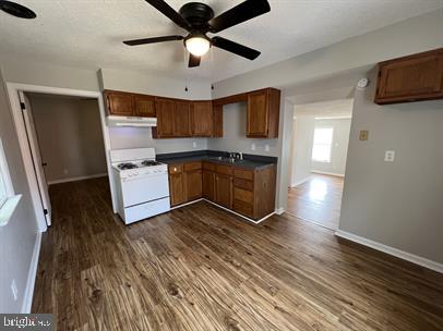 kitchen featuring white range, sink, dark hardwood / wood-style floors, and ceiling fan