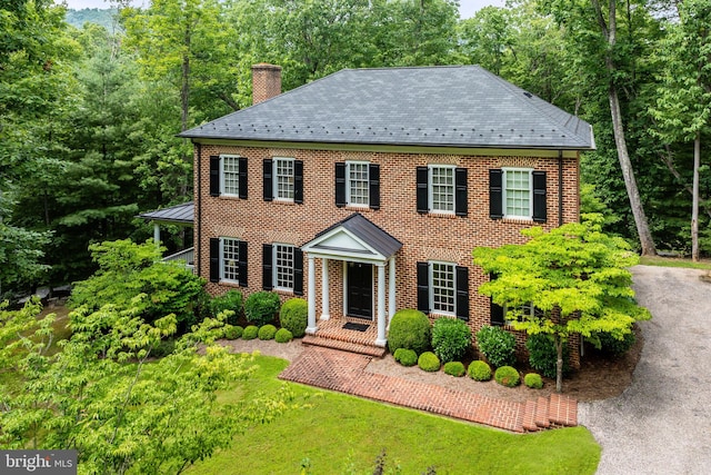 colonial home featuring a front lawn