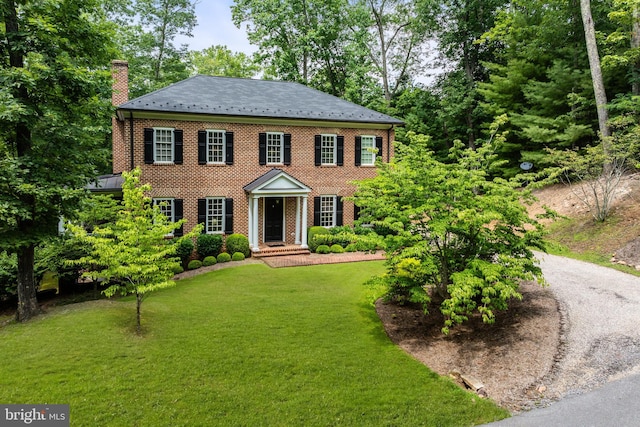 colonial-style house featuring a front yard