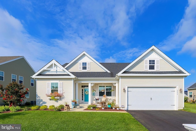 craftsman-style house featuring a garage, covered porch, and a front lawn