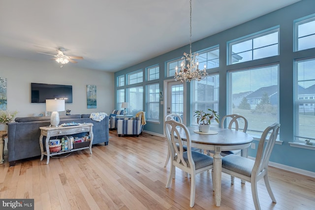 dining room featuring light hardwood / wood-style floors, ceiling fan with notable chandelier, and plenty of natural light