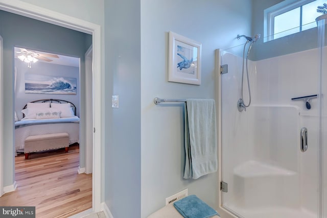 bathroom featuring wood-type flooring, ceiling fan, and walk in shower