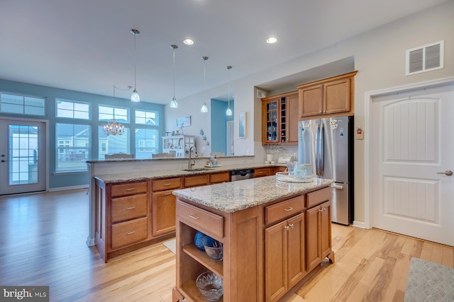 kitchen with appliances with stainless steel finishes, light hardwood / wood-style flooring, a center island, and kitchen peninsula