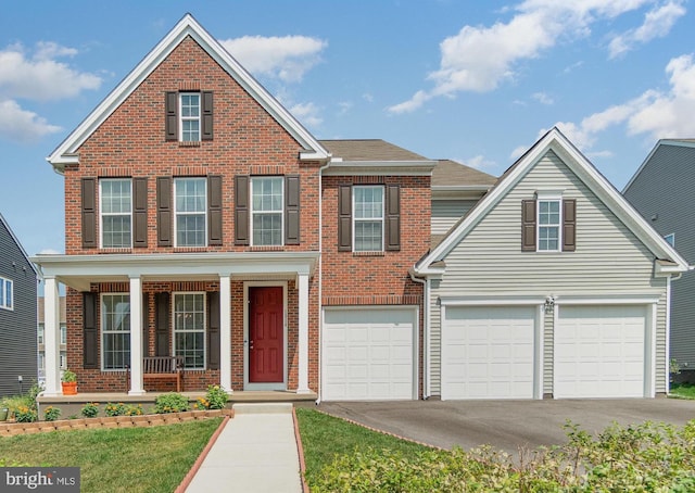 traditional-style home with brick siding, covered porch, an attached garage, and driveway