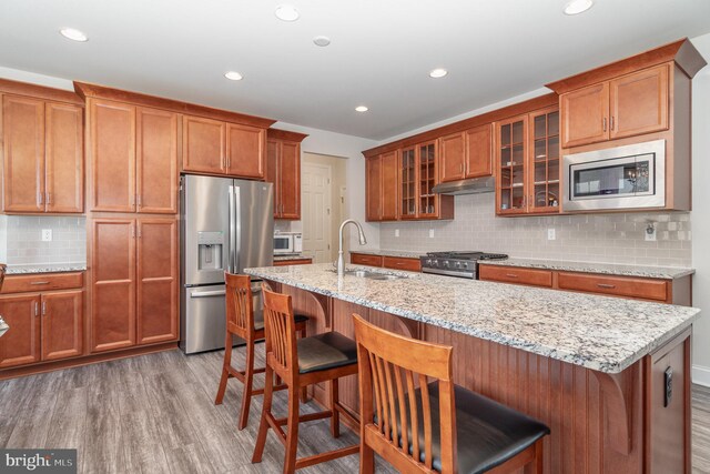 kitchen featuring sink, decorative backsplash, hardwood / wood-style flooring, and stainless steel appliances