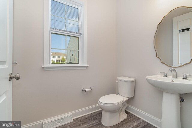 bathroom featuring wood-type flooring and toilet