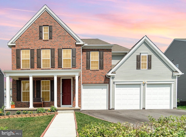 traditional home with brick siding, covered porch, and driveway