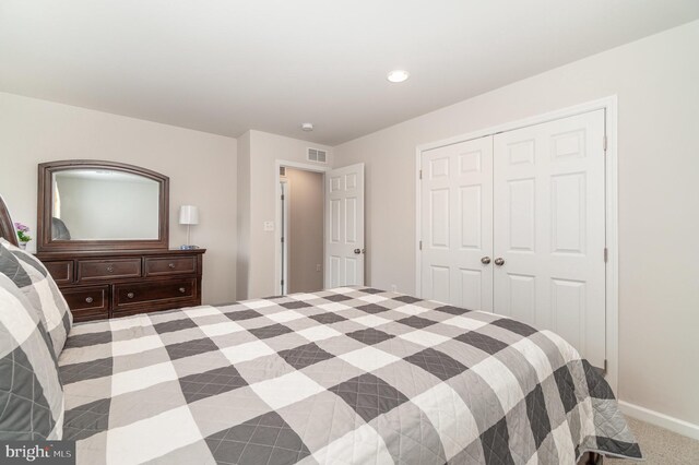 bedroom featuring light carpet and a closet